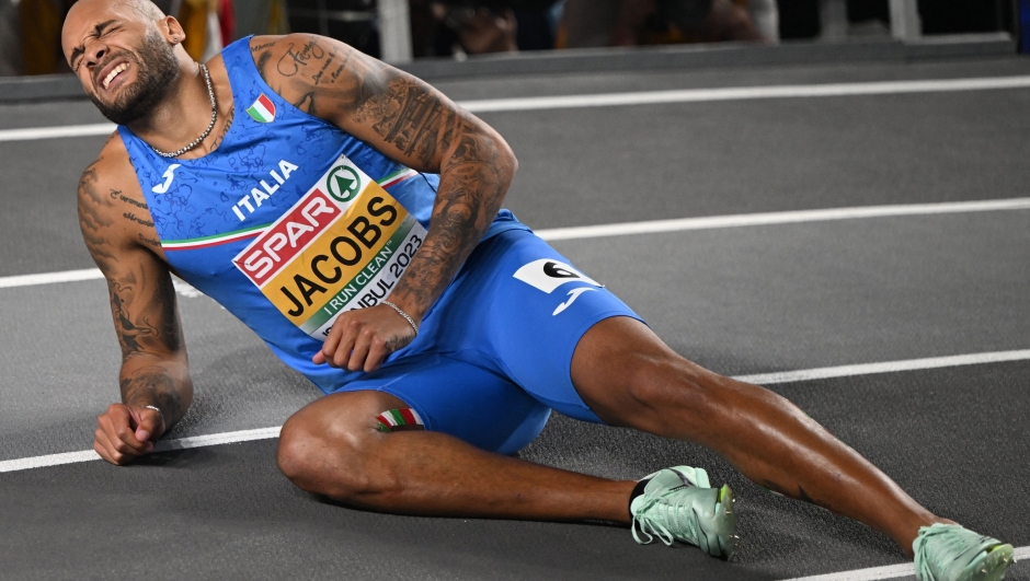 Italy's Lamont Marcell Jacobs lies on the track after his second place in the finals of the men's 60 metres during The European Indoor Athletics Championships at The Atakoy Athletics Arena in Istanbul on March 4, 2023. (Photo by OZAN KOSE / AFP)