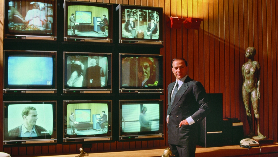 Silvio Berlusconi, Italian politician and businessman, beside an array of televisions. (Photo by �� Vittoriano Rastelli/CORBIS/Corbis via Getty Images)
