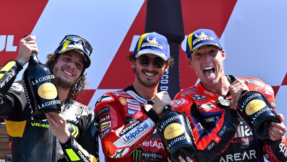 TOPSHOT - First-placed Ducati Lenovo Team's Italian rider Francesco Bagnaia (C), second-placed Mooney VR46 Racing's Italian rider Marco Bezzecchi (L) and third-placed Aprilia Racing's Spanish rider Aleix Espargaro celebrate on the podium after the Dutch MotoGP at the TT circuit of Assen, on June 25, 2023. (Photo by John THYS / AFP)