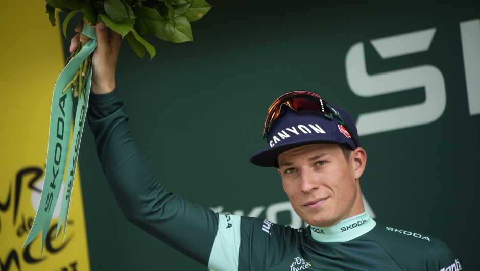 Belgium's Jasper Philipsen, wearing the best sprinter's green jersey, poses on podium after the eighth stage of the Tour de France cycling race over 201 kilometers (125 miles) with start in Libourne and finish in Limoges, France, Saturday, July 8, 2023. (AP Photo/Daniel Cole)