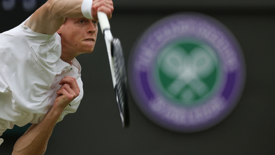 Italy's Jannik Sinner serves to Russia's Roman Safiullin during their men's singles quarter-finals tennis match on the ninth day of the 2023 Wimbledon Championships at The All England Tennis Club in Wimbledon, southwest London, on July 11, 2023. (Photo by Adrian DENNIS / AFP) / RESTRICTED TO EDITORIAL USE