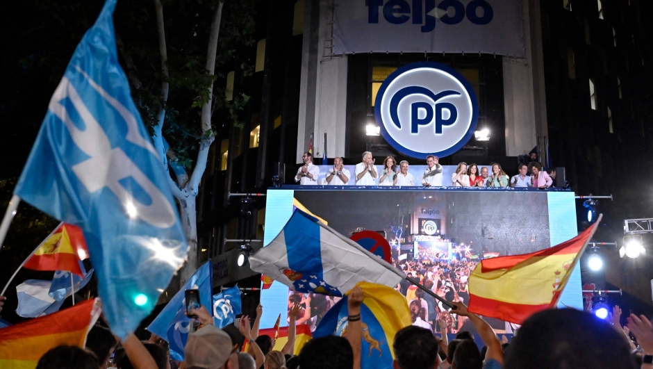 The leader and candidate of conservative Partido Popular (People's Party) Alberto Nunez Feijoo (C) gestures as he addresses supporters from a balcony of the PP headquarters in Madrid after Spain's general election on July 23, 2023. Widely expected to win today's snap election, the right-wing Popular Party was only a handful of votes ahead of the Socialists with two-thirds of the votes counted, leaving Prime Minister Pedro Sanchez a chance to cling onto power. (Photo by OSCAR DEL POZO / AFP)