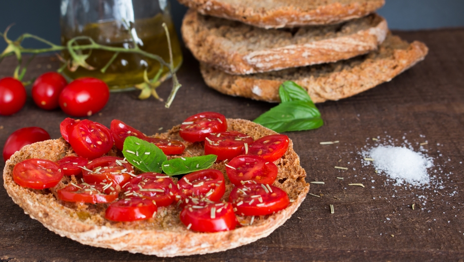 Freselle with cherry tomatoes photographed on a wooden base