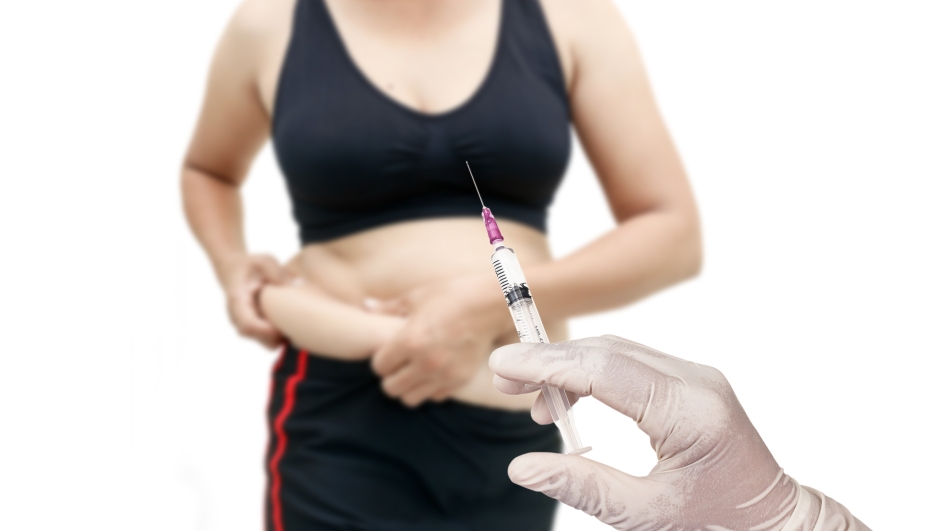 Hand holding syringe concept of weight loss surgery, liposuction.
