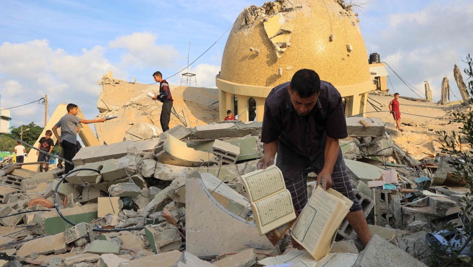 TOPSHOT - People examine the ruins of a mosque destroyed in Israeli airstrikes in Khan Yunis, southern Gaza Strip, on October 8, 2023. Fighting between Israeli forces and the Palestinian militant group Hamas raged on October 8, with hundreds killed on both sides after a surprise attack on Israel prompted Prime Minister Benjamin Netanyahu to warn they were "embarking on a long and difficult war". (Photo by SAID KHATIB / AFP)