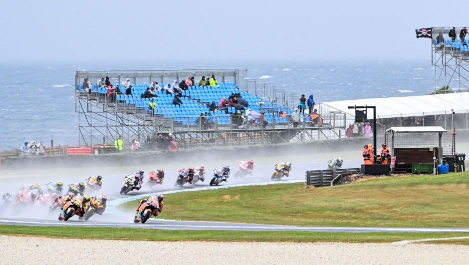 Riders race through the rain during the Moto2 race at the MotoGP Australian Grand Prix in Phillip Island on October 22, 2023. (Photo by Paul CROCK / AFP) / -- IMAGE RESTRICTED TO EDITORIAL USE - STRICTLY NO COMMERCIAL USE --