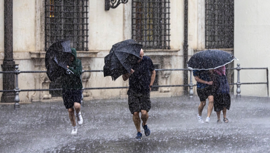 Tourists shelter from the rain with umbrellas in Place Colonna, Rome,  24 October 2023.  ANSA/MASSIMO PERCOSSI