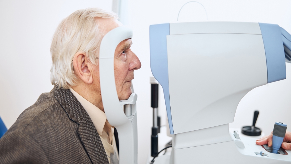 Side view of an elderly patient undergoing the air puff test performed by a qualified optometrist
