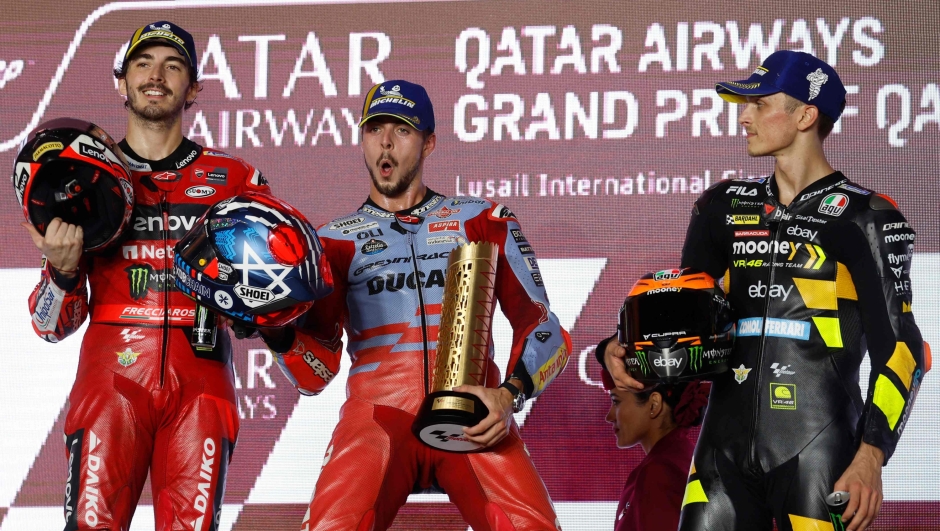 Gresini Racing's Italian race winner Fabio Di Giannantonio (C) poses on the podium with second-place Ducati Lenovo Team's Italian rider Francesco Bagnaia (L) and third-place Mooney VR46 Racing's Italian rider Luca Marini after the Moto GP Grand Prix of Qatar at the Lusail International Circuit, in the city of Lusail on November 19, 2023. (Photo by KARIM JAAFAR / AFP)