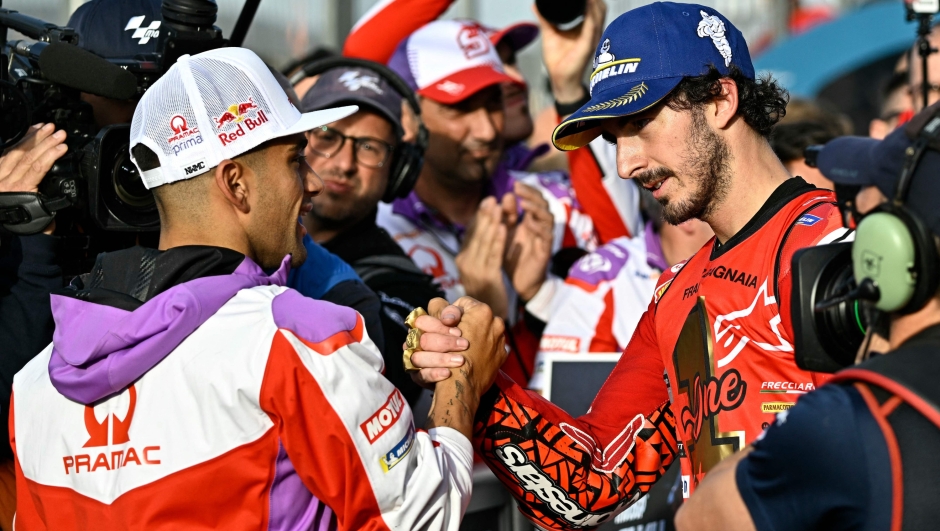 Ducati Italian rider Francesco Bagnaia (R) shakes hands with Ducati Spanish rider Jorge Martin after winning the MotoGP Valencia Grand Prix at the Ricardo Tormo racetrack in Cheste, on November 26, 2023. Italy's Francesco Bagnaia enjoyed a dream day as he retained his MotoGP world title and crowned it with victory in the final race of the season in Valencia today. The 26-year-old Ducati rider had been assured of the championship when his sole rival Jorge Martin crashed early in the race. (Photo by JAVIER SORIANO / AFP)