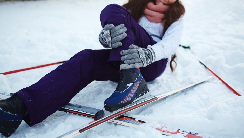 Active female fell down on snow during ski training