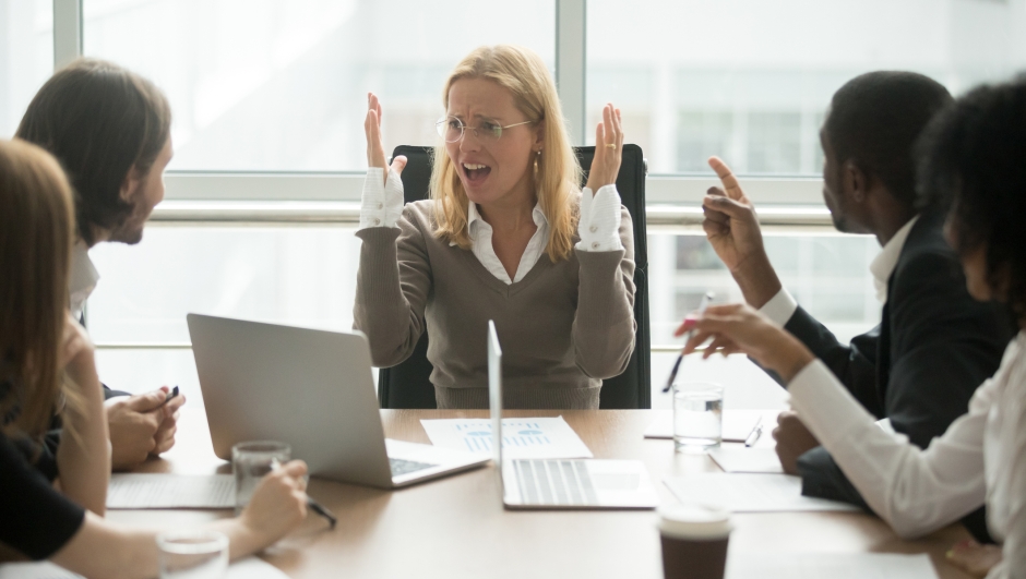 Stressed angry businesswoman arguing at meeting with diverse male colleagues, woman boss team leader confused about bad attitude and bullying, suffering from disrespect, gender discrimination at work
