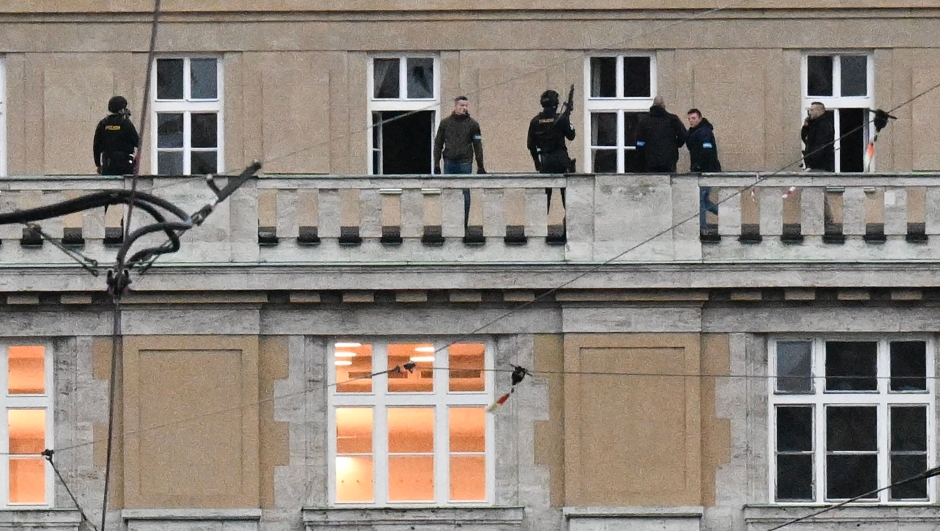 TOPSHOT - Armed police are seen on the balcony of the Charles University in central Prague, on December 21, 2023. Czech police said a shooting in a university building in central Prague has left "dead and wounded people", without providing further details. "Based on the initial information we have, we can confirm dead and wounded people on the scene," police said on X, formerly Twitter. Czech media said the shooting had occurred at the Faculty of Arts whose teachers and students were instructed to lock themselves up as the police action was under way. (Photo by Michal CIZEK / AFP)