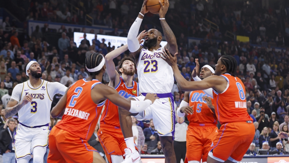 Los Angeles Lakers forward LeBron James (23) prepares to shoot between Oklahoma City Thunder guard Shai Gilgeous-Alexander (2), forward Chet Holmgren, third from left, guard Luguentz Dort (5) and forward Jalen Williams (8) as Lakers forward Anthony Davis (3) watches during the first half of an NBA basketball game Saturday, Dec. 23, 2023, in Oklahoma City. (AP Photo/Nate Billings)