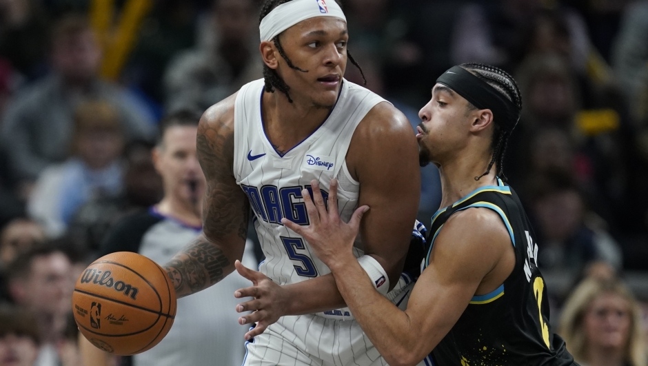 Orlando Magic's Paolo Banchero (5) is defended by Indiana Pacers' Andrew Nembhard, right, during the second half of an NBA basketball game, Saturday, Dec. 23, 2023, in Indianapolis. (AP Photo/Darron Cummings)