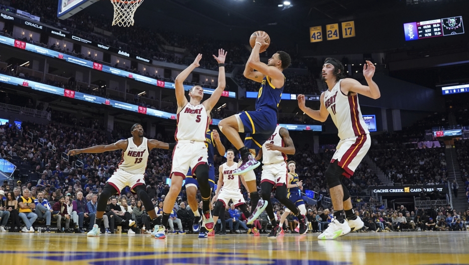 Golden State Warriors guard Stephen Curry (30) drives for a shot as Miami Heat forward Nikola Jovic (5) and guard Jaime Jaquez Jr. (11) defend during the second half of an NBA basketball game Thursday, Dec. 28, 2023, in San Francisco. (AP Photo/Loren Elliott)
