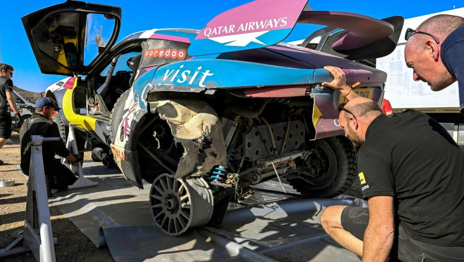 Technicians inspect Nasser Racing's Qatari driver Nasser Al-Attiyah and his French co-driver Mathieu Baumel's car at an assistance park at the end of Stage 3 of the Dakar Rally 2024, between Al Duwadimi and Al Salamiya, Saudi Arabia, on January 8, 2024. (Photo by PATRICK HERTZOG / AFP)