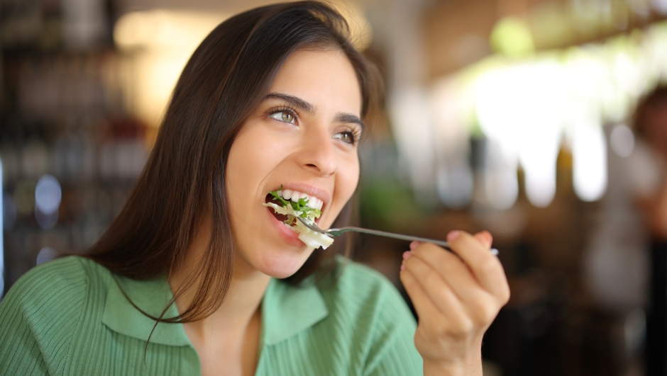Woman eating lettuce in a restaurant