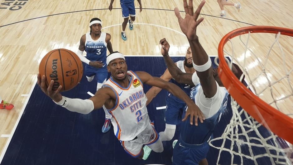 Oklahoma City Thunder guard Shai Gilgeous-Alexander (2) goes up to shoot as Minnesota Timberwolves center Naz Reid, right, defends during the first half of an NBA basketball game, Saturday, Jan. 20, 2024, in Minneapolis. (AP Photo/Abbie Parr)