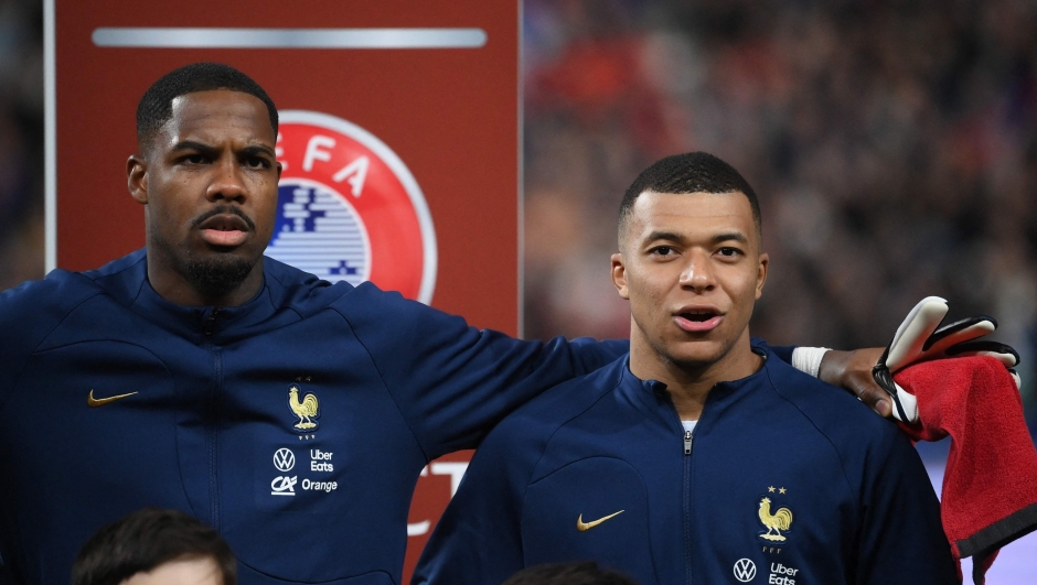 France's goalkeeper Mike Maignan (L) and France's forward Kylian Mbappe (R) sing the national anthem during the UEFA Euro 2024 qualification football match between France and Netherlands at the Stade de France in Saint-Denis, north of Paris, on March 24, 2023. (Photo by FRANCK FIFE / AFP)