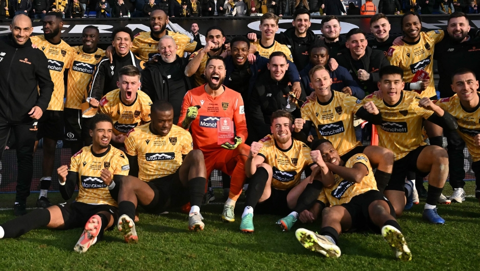 Maidstone's Brazilian goalkeeper #01 Lucas Covolan (C) poses with teammates as they celebrate winning the English FA Cup fourth round football match between Ipswich Town and Maidstone United at Portman Road, Ipswich, eastern England on January 27, 2024. Maidstone won the match 2-1. (Photo by Ben Stansall / AFP) / RESTRICTED TO EDITORIAL USE. No use with unauthorized audio, video, data, fixture lists, club/league logos or 'live' services. Online in-match use limited to 120 images. An additional 40 images may be used in extra time. No video emulation. Social media in-match use limited to 120 images. An additional 40 images may be used in extra time. No use in betting publications, games or single club/league/player publications. /