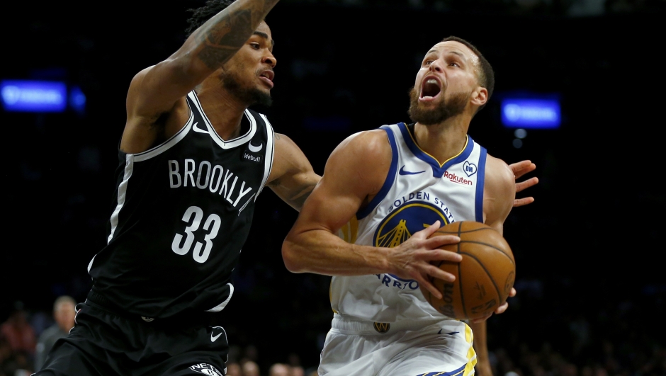 Brooklyn Nets center Nic Claxton, left, defends against Golden State Warriors guard Stephen Curry, right, during the first half of an NBA basketball game Monday, Feb. 5, 2024, in New York. (AP Photo/John Munson)