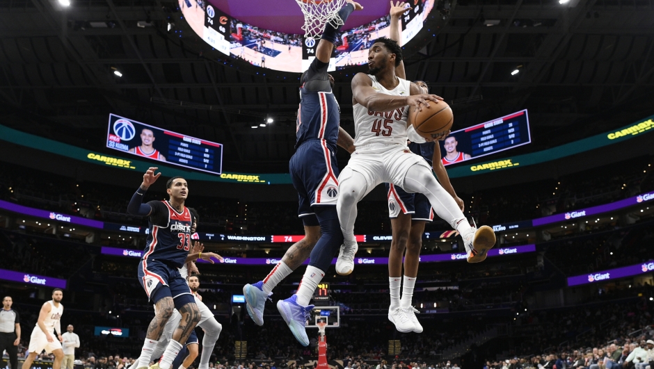 Cleveland Cavaliers guard Donovan Mitchell (45) goes to the basket against Washington Wizards center Daniel Gafford and forward Kyle Kuzma (33) during the second half of an NBA basketball game Wednesday, Feb 7, 2024, in Washington. (AP Photo/Nick Wass)