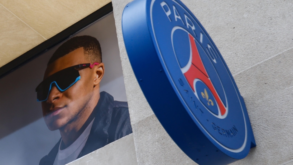 epa11158262 PSG player Kylian Mbappe's picture is seen next to PSG's logos on the official merchandising shop of the French League 1 team Paris Saint-Germain (PSG) at the Champs Elysees in Paris, France, 16 February 2024. PSG striker Kylian Mbappe announced his departure from the club at the end of the season.  EPA/Mohammed Badra