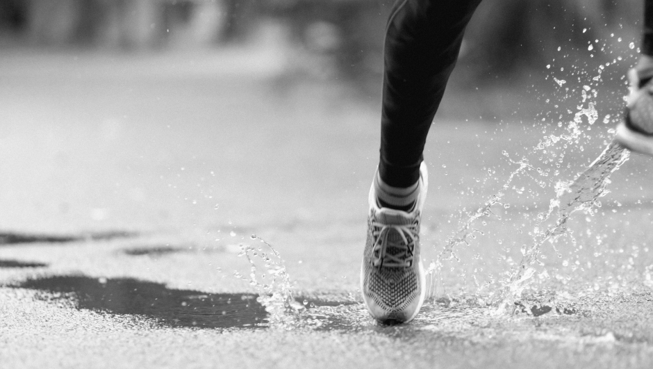Athletic man running in a rainy day.