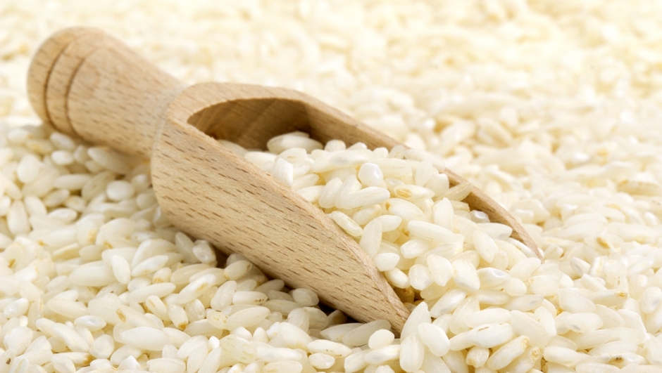 backdrop of risotto rice with wooden scoop