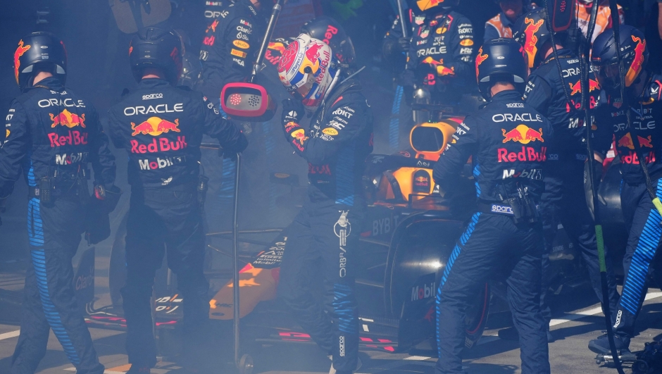 Red Bull Racing's Dutch driver Max Verstappen (C) walks back to the garage after smoke billowing from his car during the Australian Formula One Grand Prix at Albert Park Circuit in Melbourne on March 24, 2024. (Photo by Scott Barbour / POOL / AFP) / -- IMAGE RESTRICTED TO EDITORIAL USE - STRICTLY NO COMMERCIAL USE --