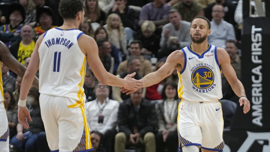 Golden State Warriors' Klay Thompson (11) and Stephen Curry (30) celebrate during the second half of an NBA basketball game against the Utah Jazz Monday, Feb. 12, 2024, in Salt Lake City. (AP Photo/Rick Bowmer)