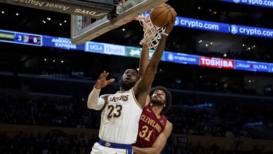 Los Angeles Lakers forward LeBron James (23) makes a lay-up under pressure from Cleveland Cavaliers center Jarrett Allen (31) during the first half of an NBA basketball game Saturday, April 6, 2024, in Los Angeles. (AP Photo/William Liang)