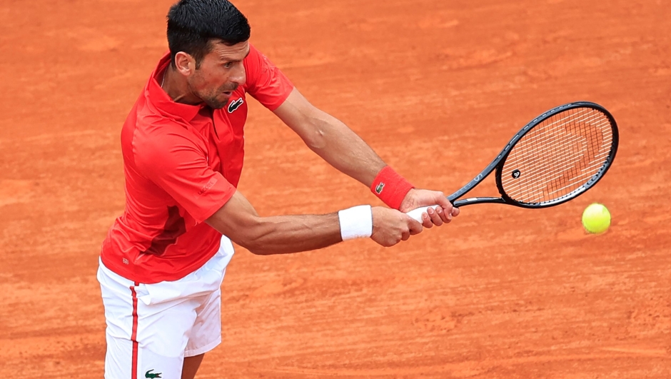 Serbia's Novak Djokovic plays a backhand return to Russia's Roman Safiullin during their Monte Carlo ATP Masters Series Tournament round of 32 tennis match on the Rainier III court at the Monte Carlo Country Club on April 9, 2024. (Photo by Valery HACHE / AFP)