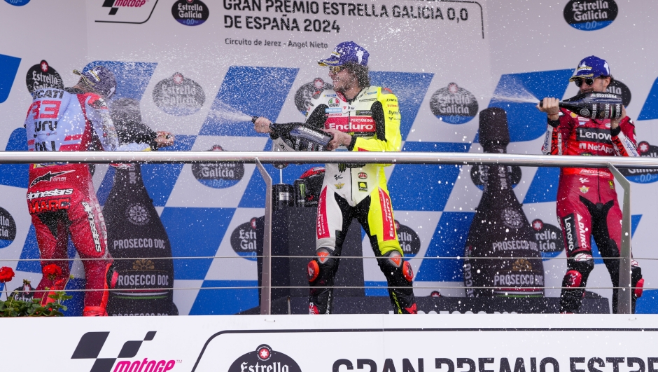Third placed Italian rider Marco Bezzecchi of the Pertamina Enduro VR46 Racing Team, center, second placed Spain's rider Marc Marquez of the Gresini Racing MotoGP, left, and race winner Italian rider Francesco Bagnaia of the Ducati Lenovo Team spray champagne on the podium after the MotoGP race of the Spanish Motorcycle Grand Prix at the Angel Nieto racetrack in Jerez de la Frontera, Spain, Sunday, April 28, 2024. (AP Photo/Jose Breton)