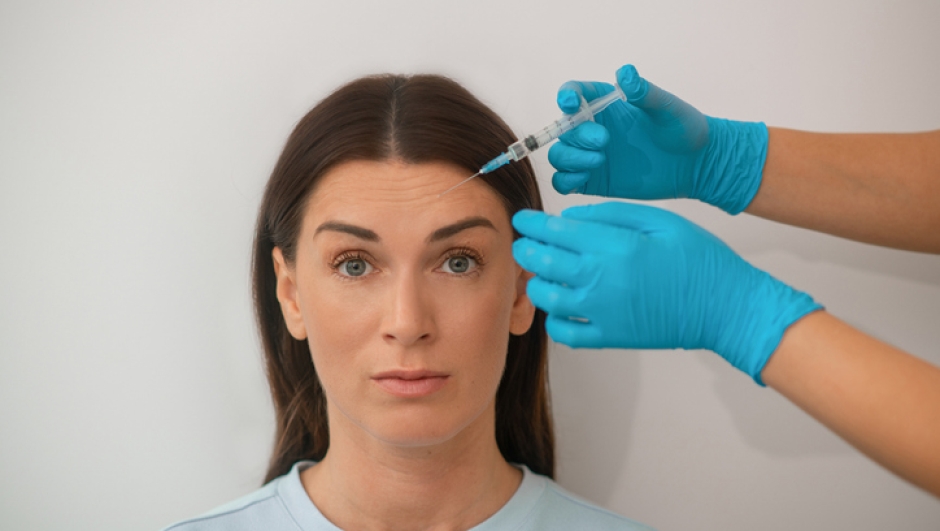 Beauty treatment. A dark-haired mid aged woman having a beaty injections procedure