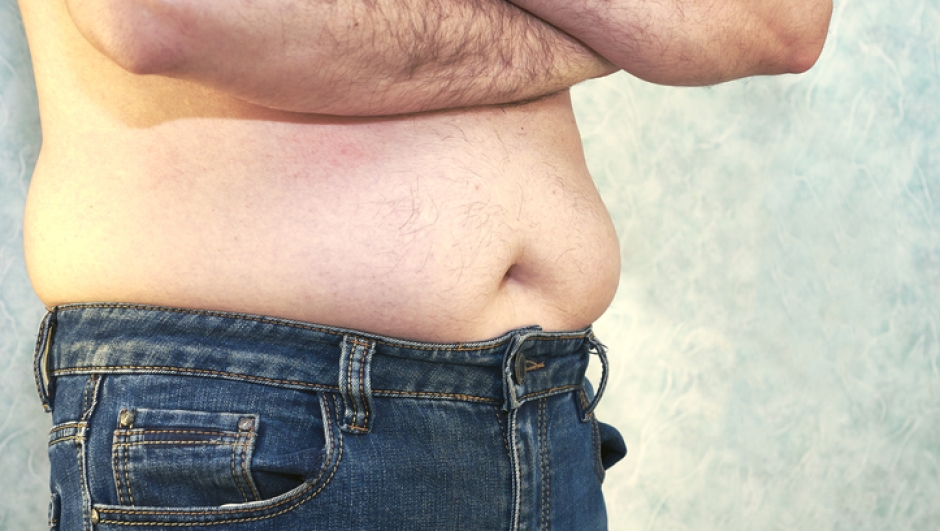 a man in jeans with a bare torso and a small belly close-up of the concept of overweight body positive