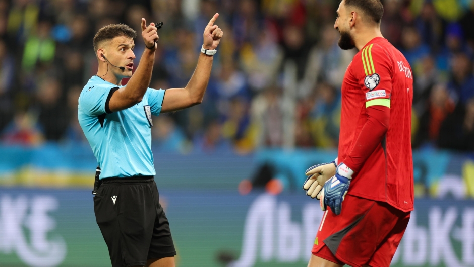 epa10986852 Referee Jesus Gil Manzano (L) gestures next to Italy's goalkeeper Gianluigi Donnarumma during the UEFA EURO 2024 Group C qualification match between Ukraine and Italy in Leverkusen, Germany, 20 November 2023.  EPA/CHRISTOPHER NEUNDORF