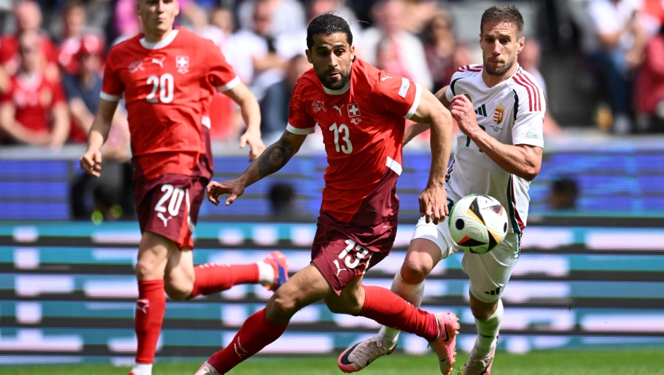 Switzerland's defender #13 Ricardo Rodriguez (C) is chassed by Hungary's forward #19 Barnabas Varga during the UEFA Euro 2024 Group A football match between Hungary and Switzerland at the Cologne Stadium in Cologne on June 15, 2024. (Photo by Kirill KUDRYAVTSEV / AFP)