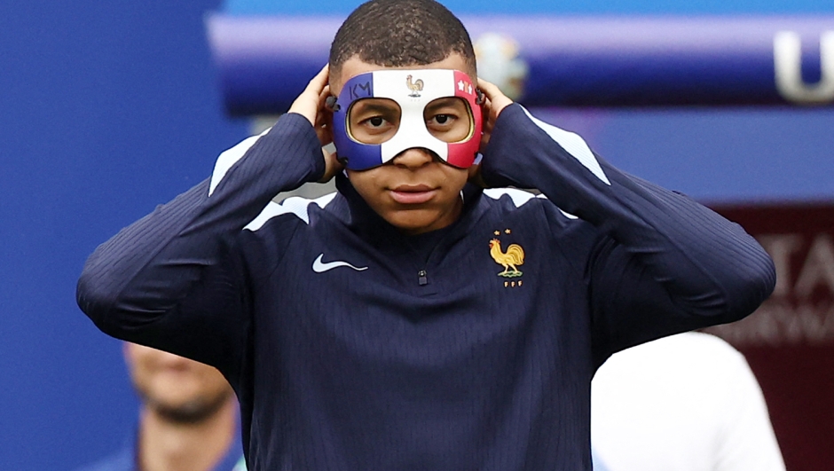 TOPSHOT - France's forward #10 Kylian Mbappe wears a face mask as he takes part in a MD-1 training session at the Leipzig Stadium in Leipzig on June 20, 2024, on the eve of their UEFA Euro 2024 Group D football match against Netherlands. (Photo by FRANCK FIFE / AFP)