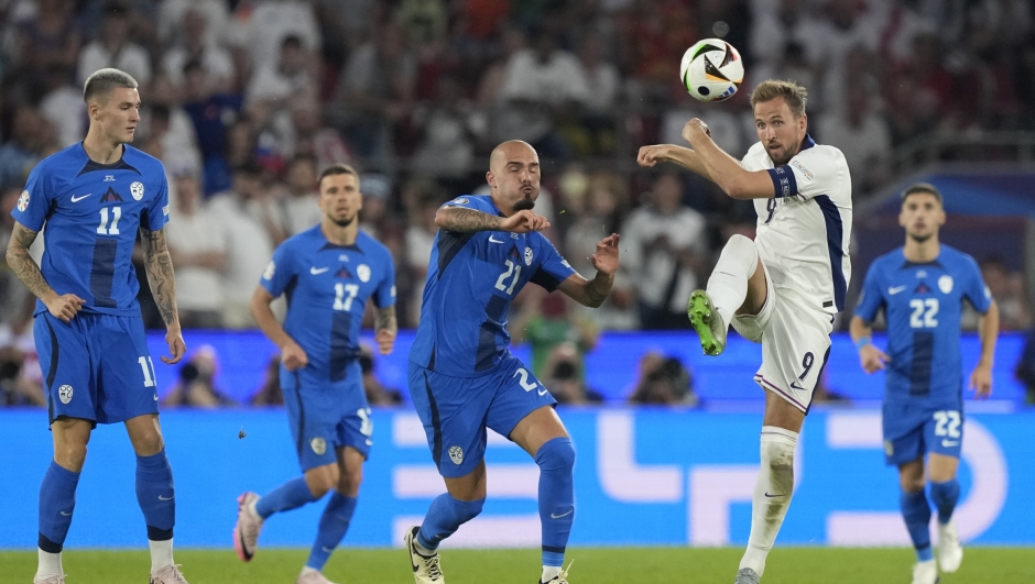 England's Harry Kane, front right, and Slovenia's Vanja Drkusic fight for the ball during a Group C match at the Euro 2024 soccer tournament in Cologne, Germany, Tuesday, June 25, 2024. (AP Photo/Martin Meissner)