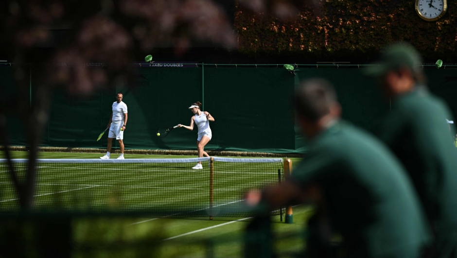 Ground staff watch on as players attend a warm up session at the All England Lawn Tennis Club in west London on June 27, 2024, the week before the Wimbledon Championships tennis tournament is due to start on July 1. (Photo by Ben Stansall / AFP) / RESTRICTED TO EDITORIAL USE