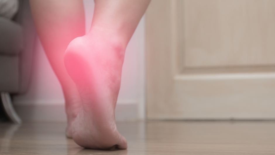 Closeup of female right foot heel pain, with red spot, plantar fasciitis