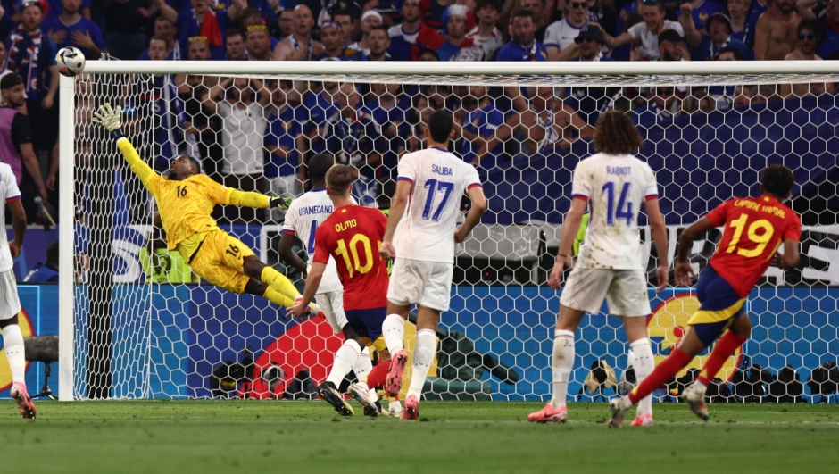 epa11468902 Lamine Yamal of Spain (R) scores the 1-1 goal against goalkeeper Mike Maignan of France (L) during the UEFA EURO 2024 semi-finals soccer match between Spain and France in Munich, Germany, 09 July 2024.  EPA/ANNA SZILAGYI