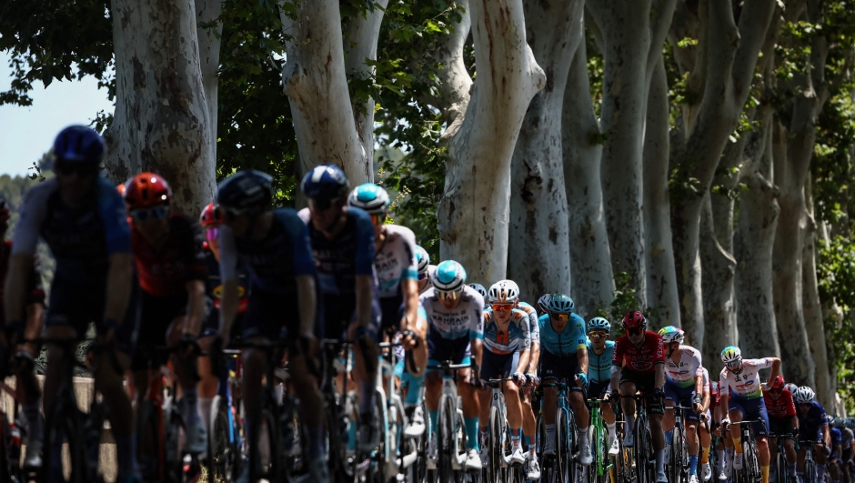The pack of riders (peloton) cycles during the 16th stage of the 111th edition of the Tour de France cycling race, 188,6 km between Gruissan and Nimes, southern France, on July 16, 2024. (Photo by Anne-Christine POUJOULAT / AFP)