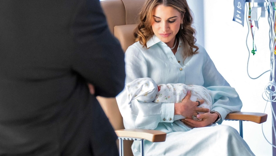 This handout picture released on August 3 by the Jordanian Royal Palace shows Jordan's King Abdullah II (L) looking on as his wife Queen rania holds their newborn granddaughter Iman in Amman. Saudi Princess Rajwa, wife of Crown Prince Hussein of Jordan, gave birth to a daughter, the royal couple's first child on August 3, the Jordanian Royal Court said in a statement. (Photo by Jordanian Royal Palace / AFP) / RESTRICTED TO EDITORIAL USE - MANDATORY CREDIT "AFP PHOTO / JORDANIAN ROYAL PALACE / YOUSEF ALLAN" - NO MARKETING NO ADVERTISING CAMPAIGNS - DISTRIBUTED AS A SERVICE TO CLIENTS
