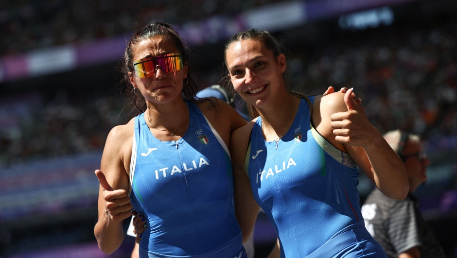 Italy's Roberta Bruni and Elisa Molinarolo celebrate after competing in the women's pole vault qualification of the athletics event at the Paris 2024 Olympic Games at Stade de France in Saint-Denis, north of Paris, on August 5, 2024. (Photo by Anne-Christine POUJOULAT / AFP)