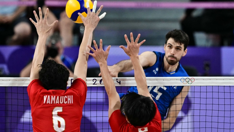 Japan's #06 Akihiro Yamauchi and Japan's #08 Masahiro Sekita jump to block the ball from Italy's #15 Daniele Lavia (back R) during the volleyball men's quarter-final match between Italy and Japan during the Paris 2024 Olympic Games at the South Paris Arena 1 in Paris on August 5, 2024. (Photo by Miguel MEDINA / AFP)