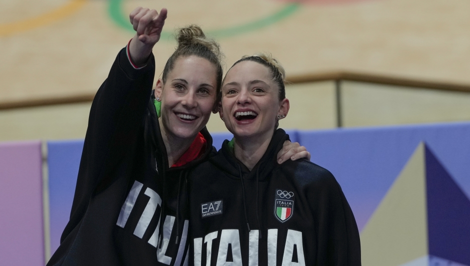 Italy's Chiara Consonni and Vittoria Guazzini, left, celebrate winning the gold medal of the women's madison event, at the Summer Olympics, Friday, Aug. 9, 2024, in Paris, France. (AP Photo/Ricardo Mazalan)