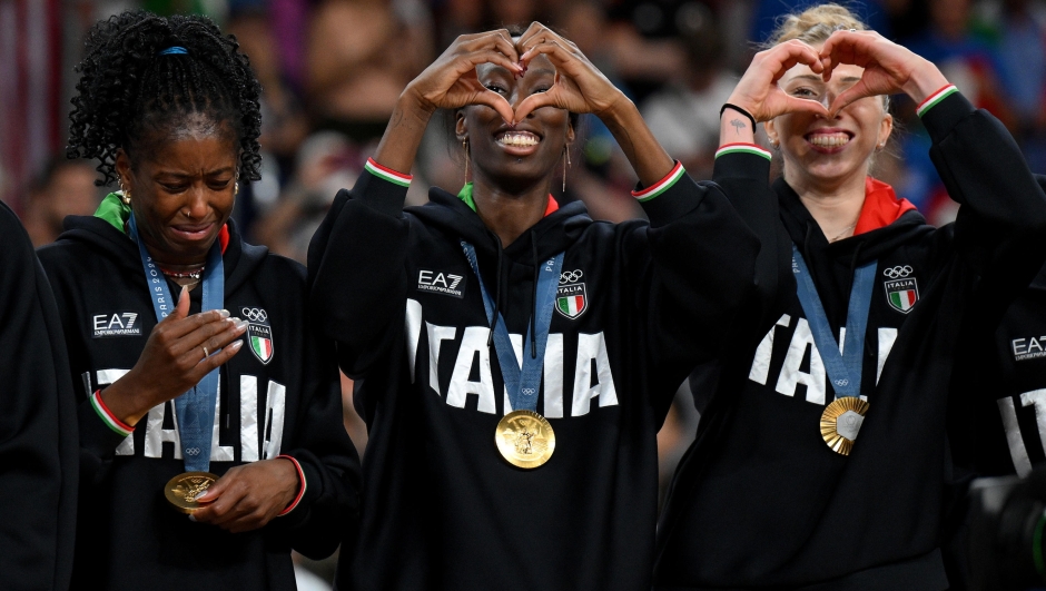 Italy's Paola Ogechi Egonu (C) and Myriam Fatime Sylla (L) celebrate on the podium after winning the Women's gold medal match between USA and Italy of the Volleyball competitions in the Paris 2024 Olympic Games, at the South Paris Arena in Paris, France, 11 August 2024. ANSA/ETTORE FERRARI